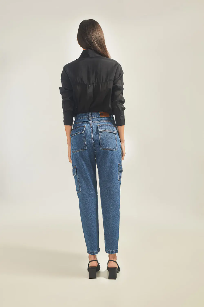 Modelo esta de costas vestindo Calça Jeans Cargo na cor Jeans Medio e jaqueta LINI Brazil.