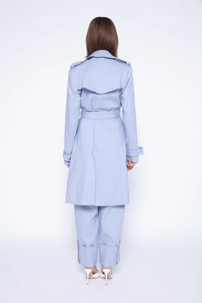 Modelo esta de costas vestindo TRENCH COAT ANTONIETTA na cor AZUL CLAROe CALÇA ANTONIETTA LINI Brazil.